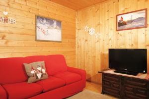 泰塞罗CASA PAMPEAGO - Sulle piste da sci del Latemar的客厅配有红色沙发和平面电视