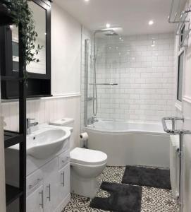 贝尔法斯特Home on Hamill Street的浴室配有盥洗盆、卫生间和浴缸。