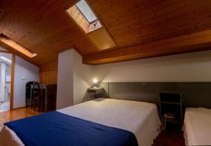 布拉加圣尼古拉酒店的一间卧室设有一张大床和天窗