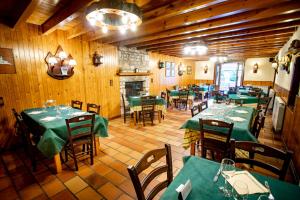 托尔拉露营谷布甲雷洛旅馆的一间设有绿色桌椅和壁炉的餐厅