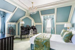 伦敦希尔顿伦敦宾利酒店的一间卧室配有一张床、一张书桌和一个吊灯。