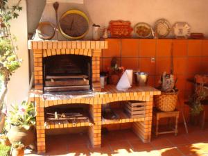 奥利韦拉-杜拜鲁Casa Rural Oliveira do Bairro的厨房中间的砖炉