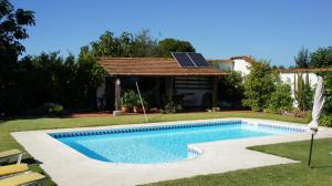奥利韦拉-杜拜鲁Casa Rural Oliveira do Bairro的一个带太阳能屋顶的庭院内的游泳池