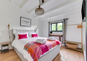 StradbrokeWoodpecker Lodge的卧室配有带粉红色枕头的大型白色床