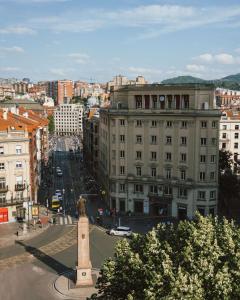 毕尔巴鄂Radisson Collection Bilbao的街道中间有钟楼的一个城市