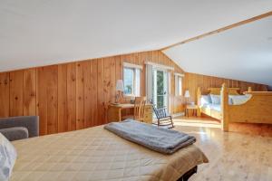 萨克雷克尔萨格奈MontFJORD - Chalets, vue spectaculaire et SPA. ChantaFJORD #4的卧室配有一张床铺,位于带木墙的房间内
