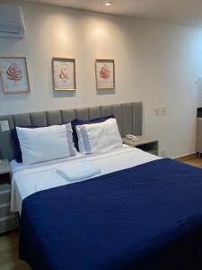 坎普斯戈伊塔卡济斯Flat no Transamerica Hotel的一间卧室配有一张大床,提供蓝色的床单和枕头