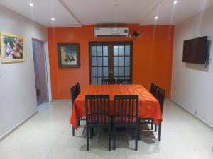门多萨1670 House的一间拥有橙色墙壁和桌椅的用餐室