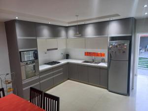 门多萨1670 House的厨房配有灰色橱柜和不锈钢冰箱