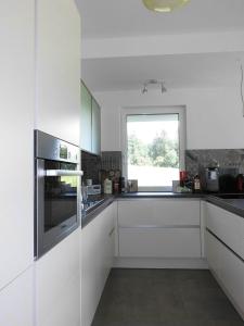 塞博登利彻布历克度假屋的厨房配有白色橱柜和窗户。