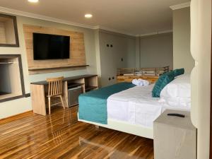 AguadasHotel Entre Brumas的一间卧室配有一张大床和电视