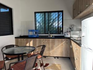 南迪Pasifika Guesthouse的厨房配有桌椅和水槽。