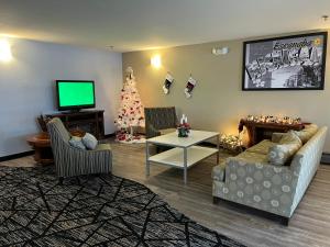 埃斯卡诺巴埃斯卡诺巴速8酒店的客厅配有圣诞树和电视