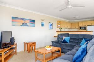 彩虹海滩Sharon Lee 2的客厅配有蓝色的沙发和电视