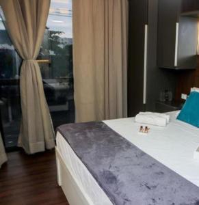 卡波布里奥Pousada do Braga的一间卧室设有一张床、一个窗户和一间浴室
