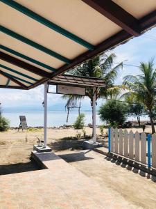 吉利阿尔Youpy Bungalows的海滩上的凉亭,带有栅栏和海洋