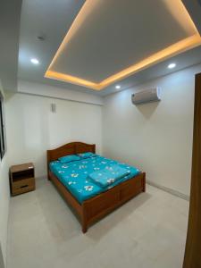 芽庄Coastal House Nha Trang的一间卧室配有一张带蓝色棉被的床