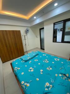 芽庄Coastal House Nha Trang的卧室配有蓝色的被子和鲜花