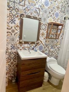 索里托斯Qeru House的一间带水槽、卫生间和镜子的浴室