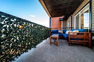 埃德蒙顿Bright Luxe Condo, AC, Top Floor, King Bed, Balcony!的一个带蓝色沙发和植物的庭院