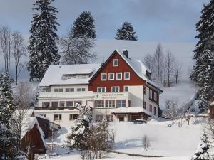 费尔德伯格夏日高山酒店的雪中的一个红色和白色的大房子