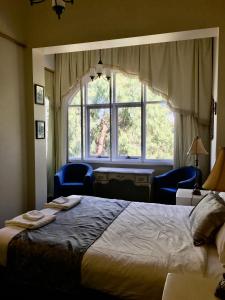 墨尔本图拉克庄园酒店的一间卧室设有一张床和一个大窗户
