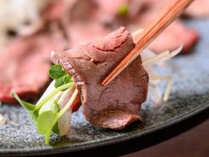 津市Hotel Tsu Center Palace的一块肉放在盘子上,上面有筷子