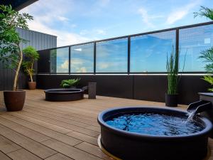 津市Hotel Tsu Center Palace的植物丛生建筑屋顶上的热水浴池