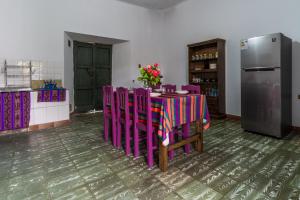苏克雷Dragonfly Guest House的厨房配有带紫色椅子的桌子和冰箱