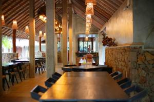 卡尔皮蒂耶Hiru Resort and Kite Surfing的餐厅设有一张大型木桌和椅子