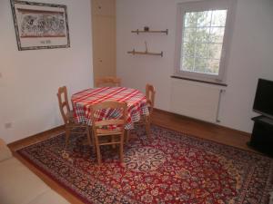 Agra波斯蒙特公寓的一间带桌椅和地毯的用餐室