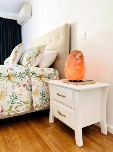 阿波罗湾Great Ocean Road Wellness and Nature Stay的一间卧室配有一张床和一张桌子,上面有花瓶