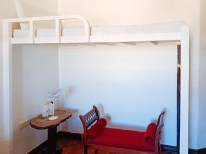 土格加劳Hotel Elinas and Restaurant的一间卧室配有一张带红色沙发和桌子的双层床。