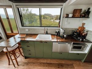 WilmotShepherd & Sprout Boutique Tiny House - Cradle Country的厨房配有水槽和带窗户的台面