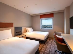 秋田ANA Crowne Plaza Akita, an IHG Hotel的酒店客房配有两张床和一张书桌