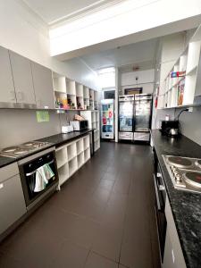 悉尼唐宁旅舍的一间大厨房,配有白色橱柜和电器