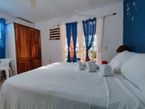 拉斯特拉纳斯贾尔丁德尔加勒比公寓式酒店的卧室配有白色大床、蓝色的墙壁和窗户