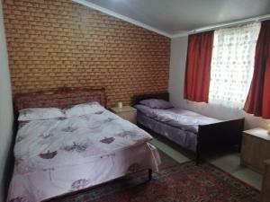 BjniGetap in Bjni的一间卧室设有两张床和砖墙