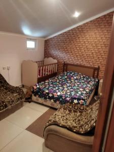 BjniGetap in Bjni的一间卧室设有两张床和砖墙