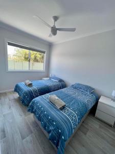 朱里恩湾Jurien Beachfront Chalets的一间卧室配有两张床和吊扇