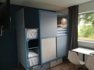Vern-sur-SeicheAtao Residence- Rennes Sud的客房设有蓝色橱柜、书桌和窗户。