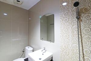 北干巴鲁Paus Guest House Pekanbaru的一间带卫生间、水槽和镜子的浴室