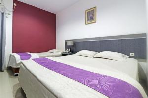 北干巴鲁Paus Guest House Pekanbaru的卧室内两张并排的床