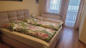 RantenGästehaus Raab的一间卧室配有一张带花卉毯子的床