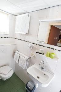 斯希蒙尼克奥赫维斯特布伦公寓的白色的浴室设有水槽和卫生间。
