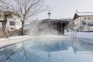 齐勒谷地里德Mari Pop Hotel的雪中带游泳池的房子