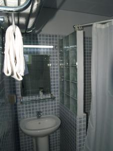 路易港Champ de Mars B&B的蓝色瓷砖浴室设有水槽和镜子
