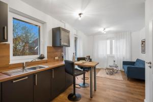 奥尔登堡Nadorst Residenz的厨房以及带书桌和桌子的客厅。