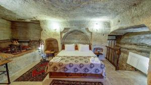 格雷梅Chelebi Cave House Hotel Over 6的石头间内一间卧室,配有一张床