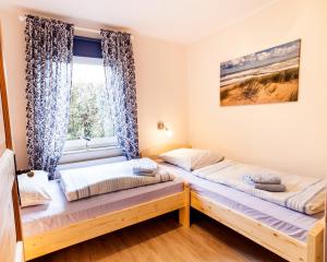旺格兰Frieslandstern - Ferienhof und Hotel的带窗户的客房内的两张床